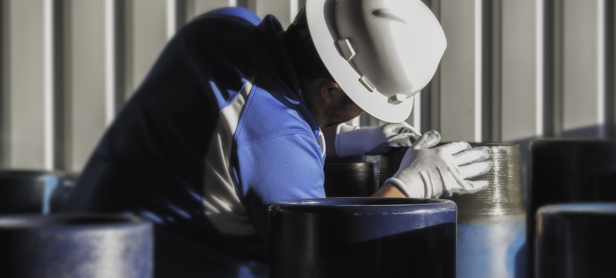 Worker inspecting tubulars carefully